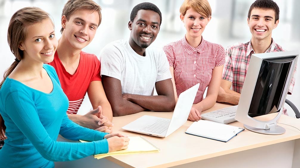 A group of students studying together around a computer