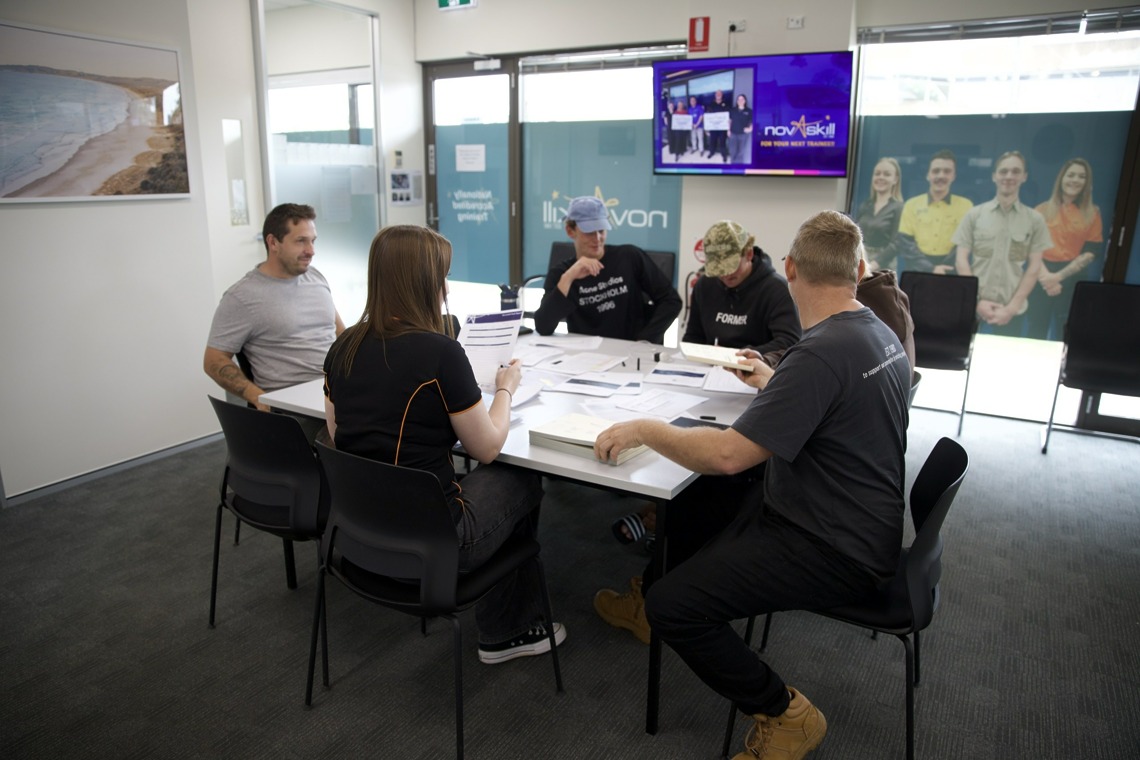 Novaskill employer and apprentices reviewing paperwork